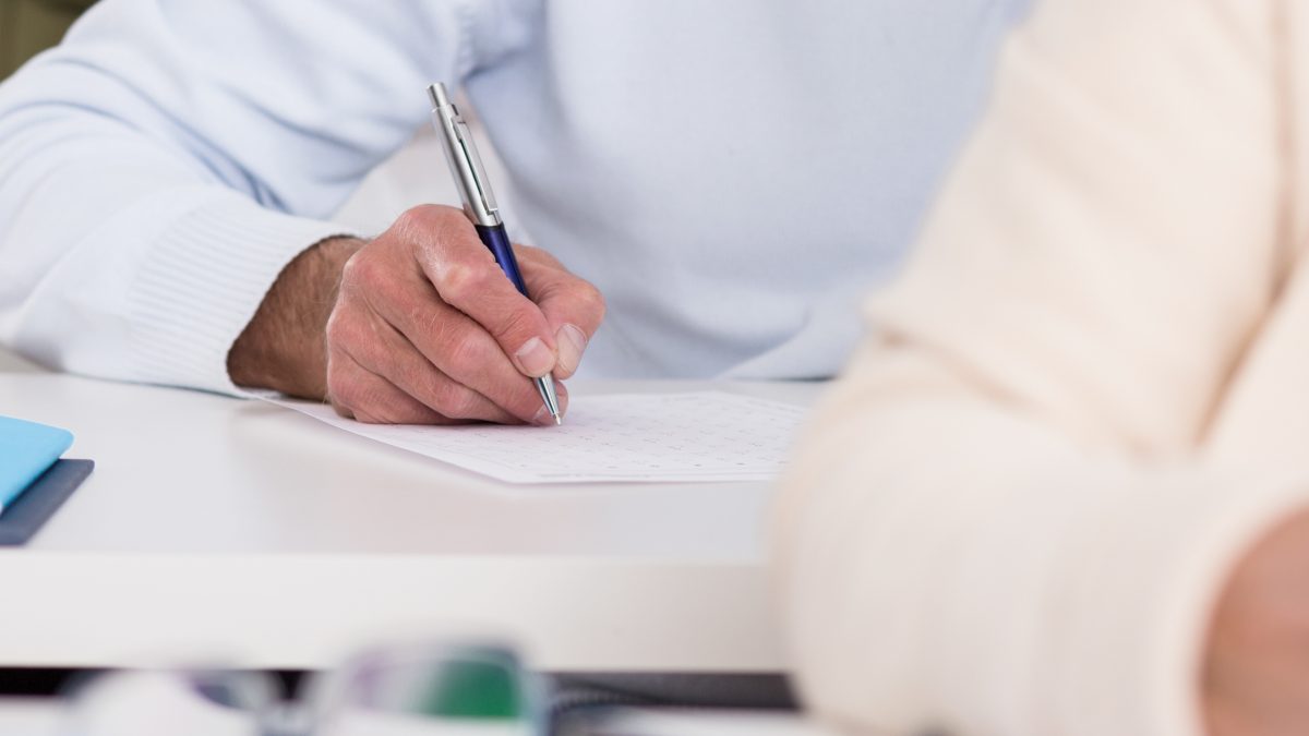 Close-up of senior students hands during writing an exam