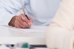 Close-up of senior students hands during writing an exam