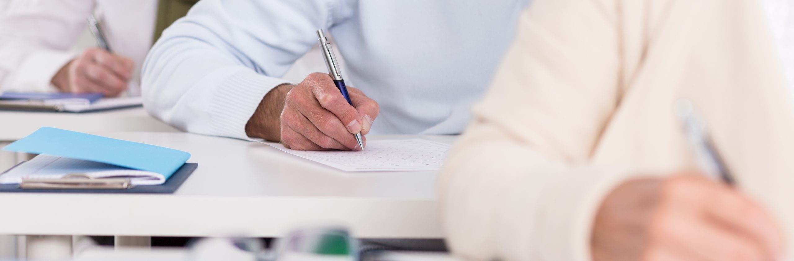 Close-up of senior students hands during writing an exam