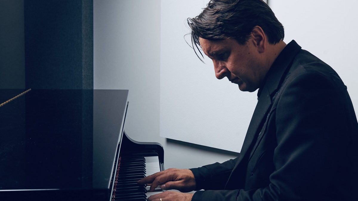 A man looks at the keys while playing piano.