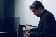 A man looks at the keys while playing piano.