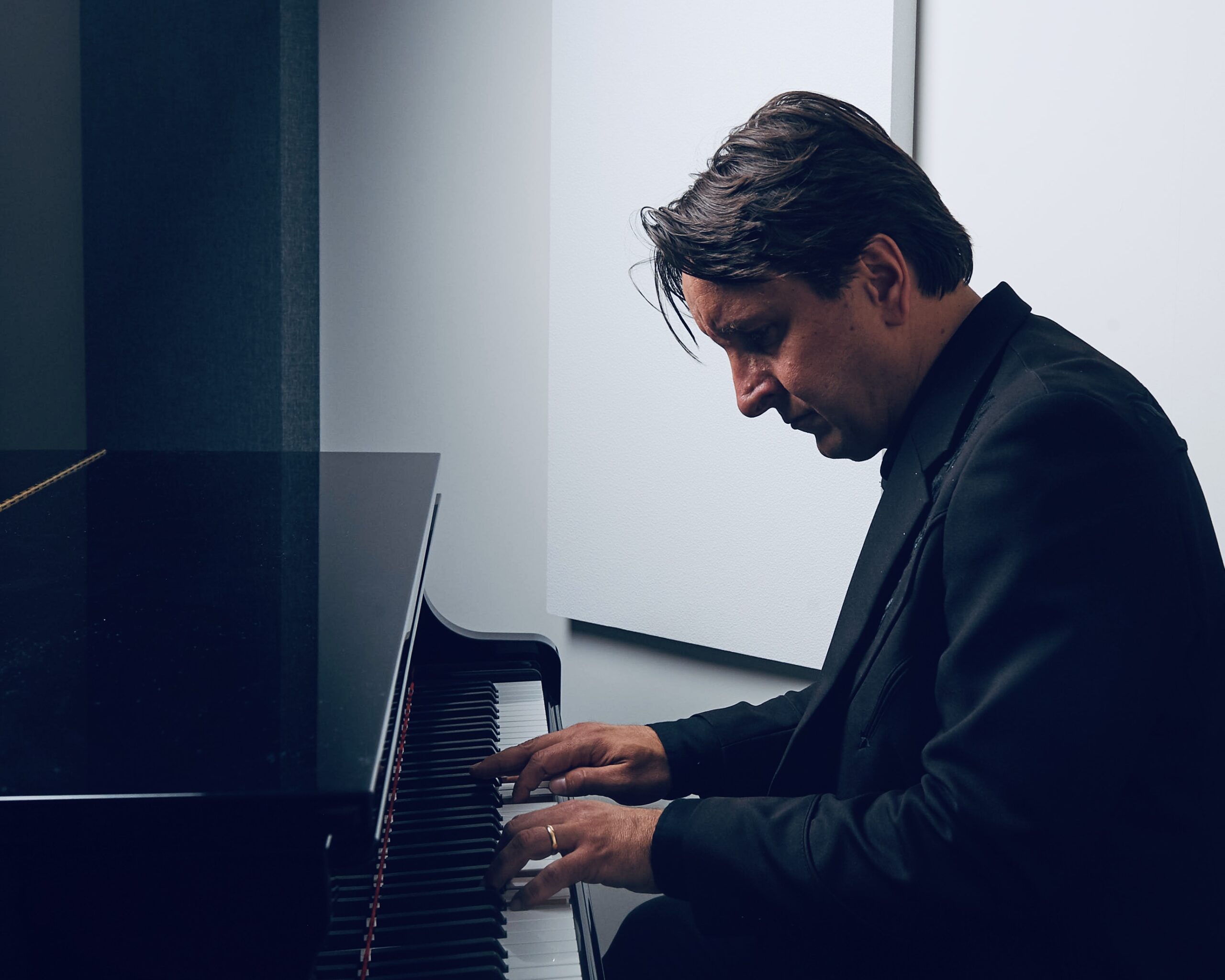 A man looks at the keys while playing piano.
