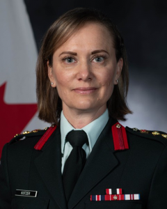 Portrait photo of a woman in military dress uniform, with a Canadian flag in the background.